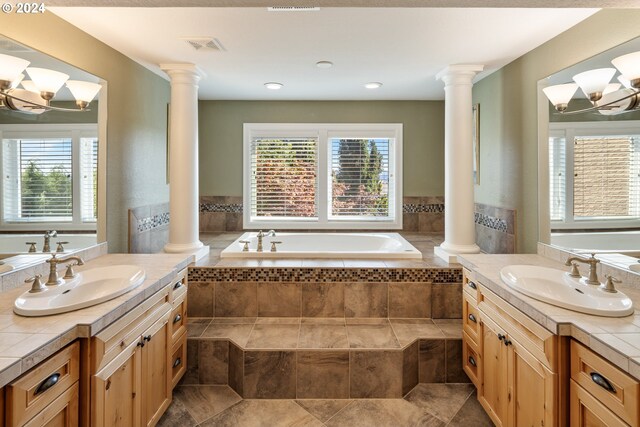 bathroom with vanity, tiled bath, and a notable chandelier