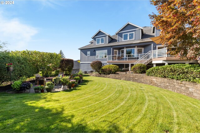 rear view of house with a lawn and a wooden deck