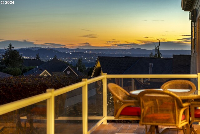 balcony at dusk featuring a mountain view