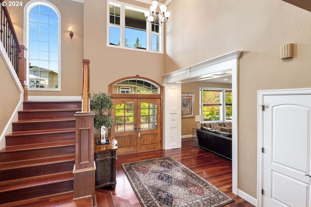 foyer featuring a high ceiling, french doors, a chandelier, and dark hardwood / wood-style floors