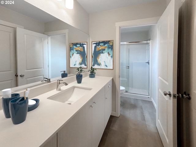 bathroom with vanity, wood-type flooring, a shower with door, and toilet