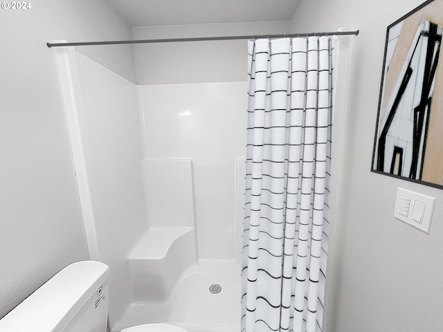 bathroom featuring toilet and a shower with shower curtain