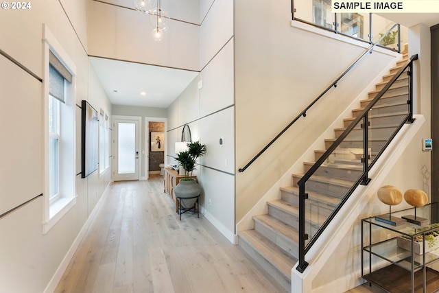 stairs featuring a healthy amount of sunlight and light wood-type flooring