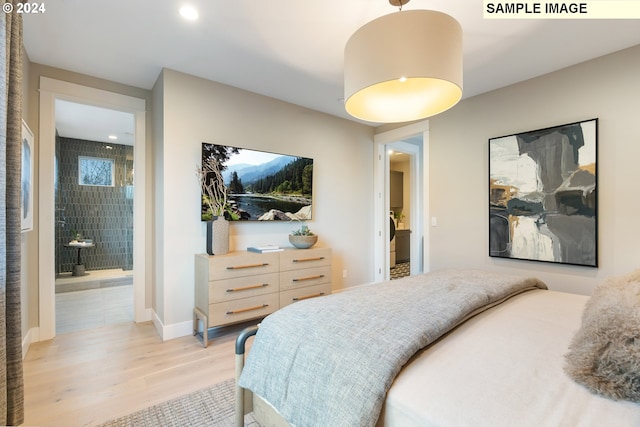 bedroom with connected bathroom and light hardwood / wood-style floors