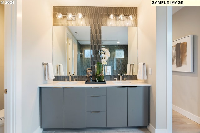 bathroom with double vanity, hardwood / wood-style flooring, and toilet