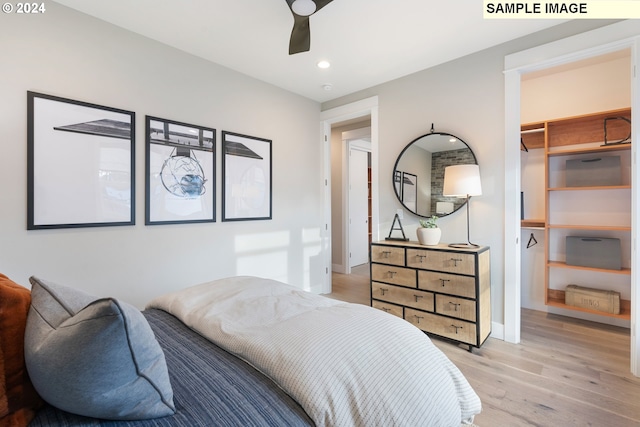 bedroom featuring ceiling fan, light hardwood / wood-style floors, a closet, and a walk in closet