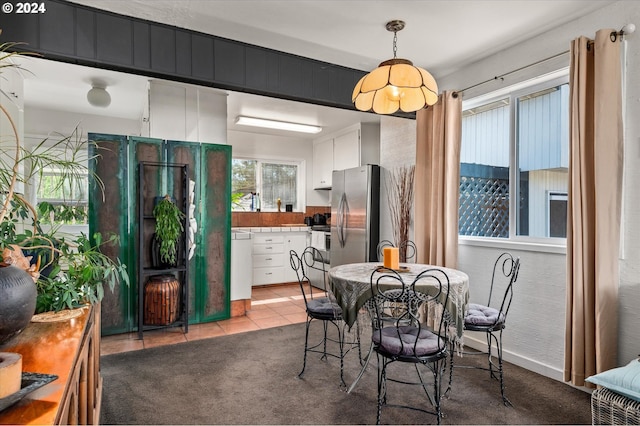 dining area featuring light carpet and light tile patterned flooring