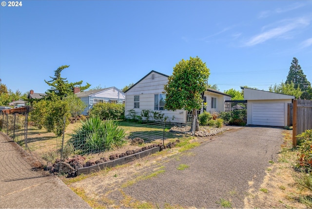 single story home featuring an outbuilding, driveway, fence, and a garage