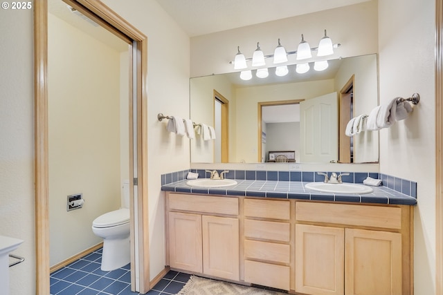 full bath featuring double vanity, tile patterned flooring, a sink, and toilet