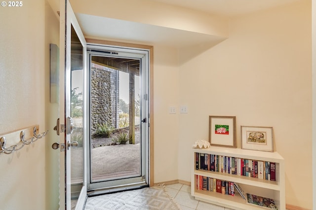 doorway to outside with tile patterned flooring and baseboards