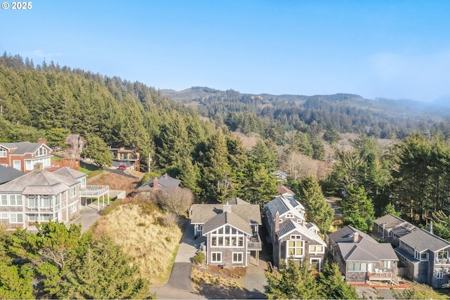 drone / aerial view featuring a residential view and a wooded view