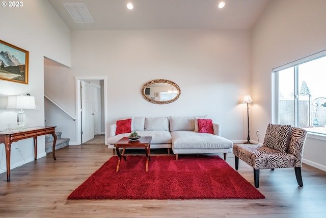 living room with light hardwood / wood-style flooring and a high ceiling