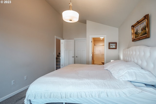 bedroom with lofted ceiling, ensuite bathroom, and carpet floors