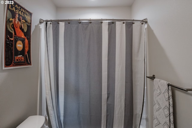 bathroom featuring curtained shower and toilet