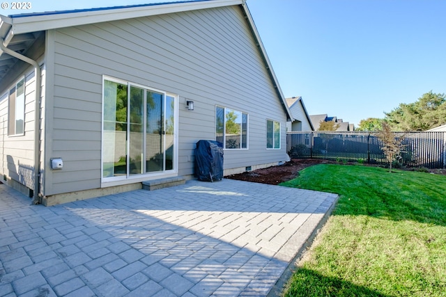 rear view of house with a patio and a lawn