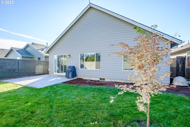 rear view of house featuring a yard and a patio