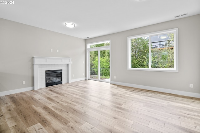 unfurnished living room featuring plenty of natural light and light hardwood / wood-style flooring