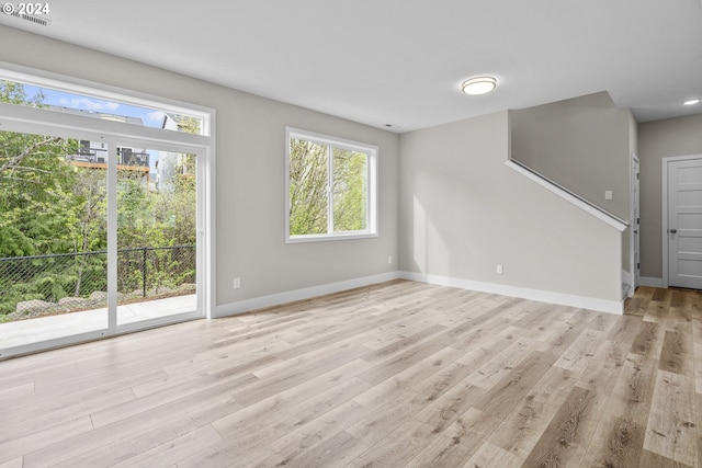 empty room with light hardwood / wood-style flooring and a wealth of natural light