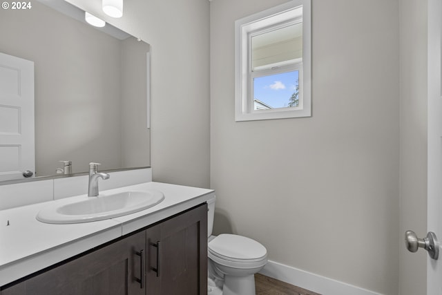 bathroom featuring wood-type flooring, oversized vanity, and toilet