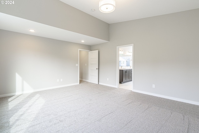 spare room featuring light carpet and a high ceiling