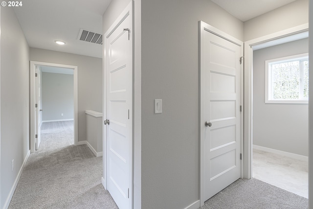 hall featuring light colored carpet