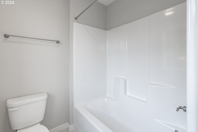 bathroom featuring shower / tub combination and toilet