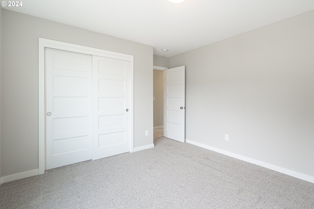 unfurnished bedroom with carpet flooring and a closet