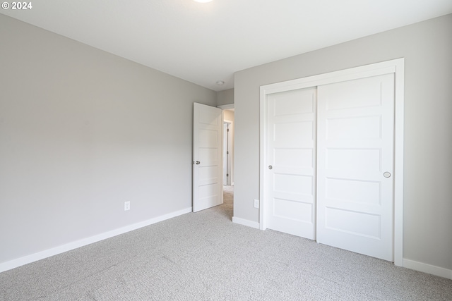 unfurnished bedroom with a closet and carpet flooring