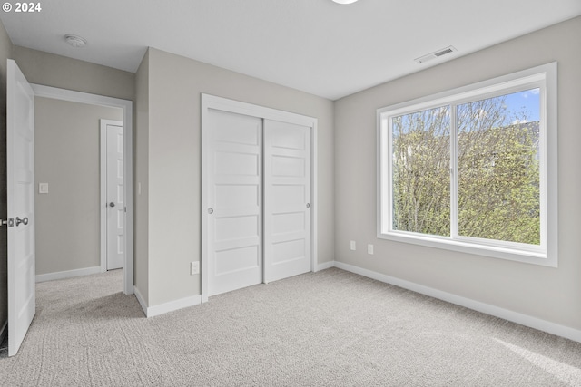 unfurnished bedroom featuring a closet, multiple windows, and carpet flooring