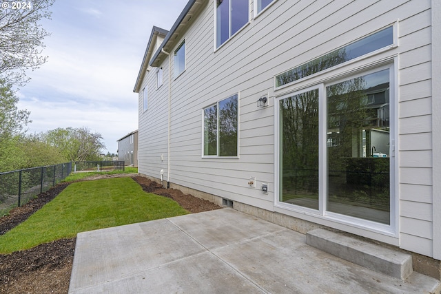 view of property exterior featuring a lawn and a patio