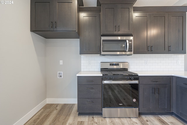 kitchen with backsplash, appliances with stainless steel finishes, dark brown cabinetry, and light wood-type flooring