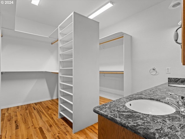 12405 SW Poppy Dr, Gaston, OR 97119 - bathroom featuring double vanity, wood finished floors, a spacious closet, and baseboards