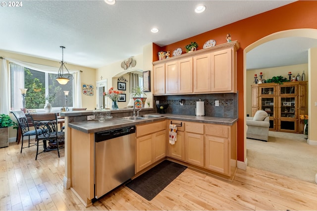 kitchen with kitchen peninsula, stainless steel dishwasher, light brown cabinets, decorative light fixtures, and light hardwood / wood-style flooring