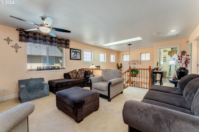 living room with a textured ceiling, a skylight, a wealth of natural light, and ceiling fan