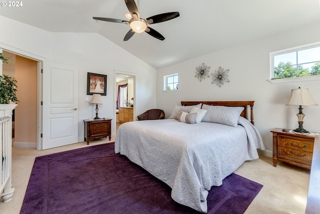 bedroom with multiple windows, ceiling fan, ensuite bath, and lofted ceiling