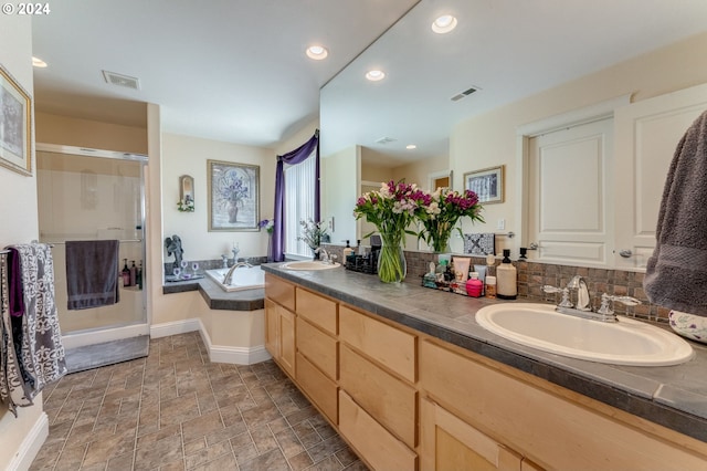 bathroom with vanity, shower with separate bathtub, and tasteful backsplash