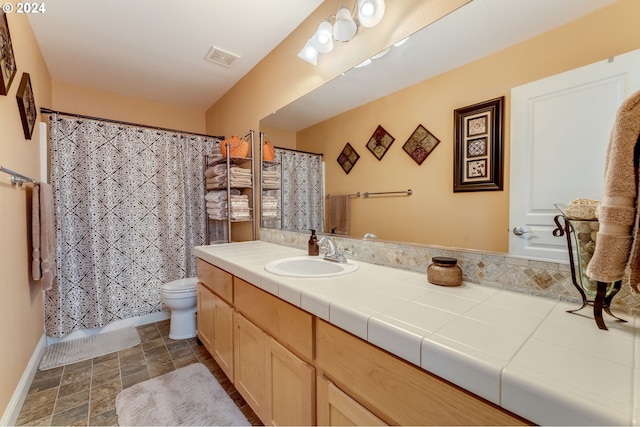 bathroom with curtained shower, vanity, and toilet