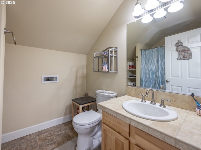 bathroom with vanity, toilet, and vaulted ceiling