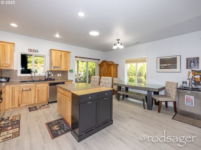 kitchen featuring a center island, sink, stainless steel dishwasher, light wood-type flooring, and light brown cabinetry