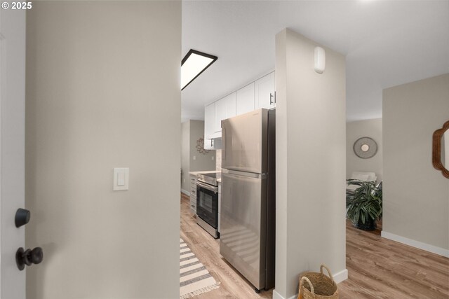 kitchen featuring white cabinets, light hardwood / wood-style floors, and appliances with stainless steel finishes