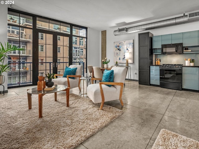 sitting room featuring concrete flooring, visible vents, baseboards, french doors, and floor to ceiling windows