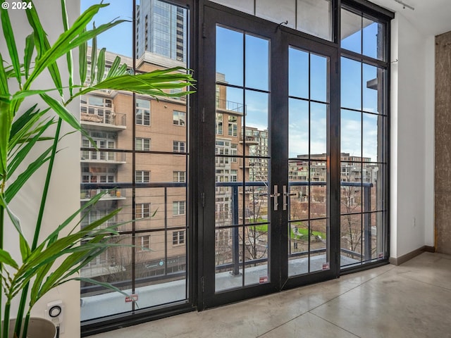 entryway featuring a healthy amount of sunlight, a high ceiling, baseboards, and concrete flooring