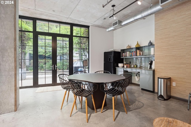 dining space with concrete flooring, french doors, and plenty of natural light