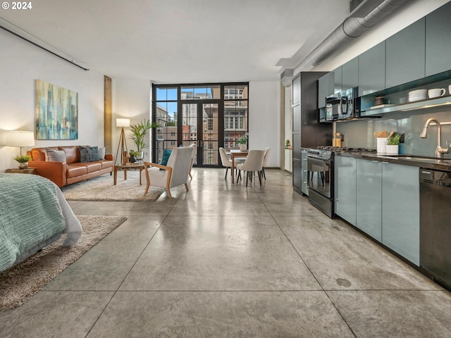 kitchen featuring concrete floors, a sink, dark countertops, and gas range