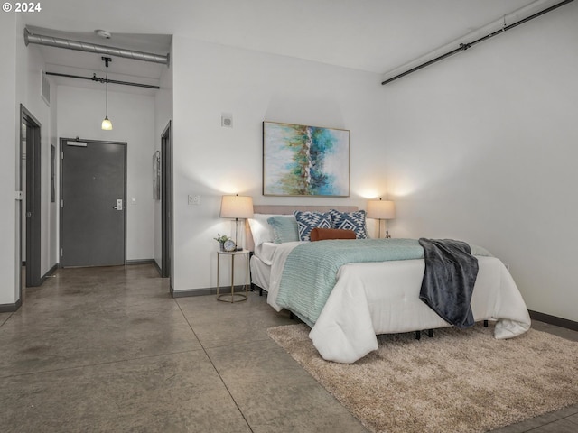 bedroom with concrete floors and baseboards