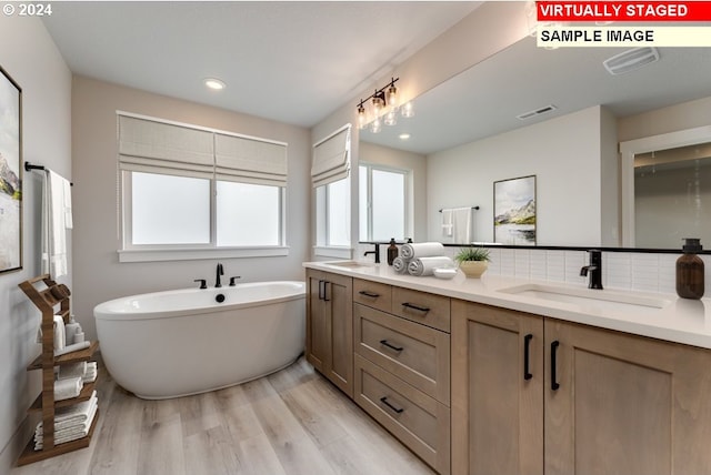 bathroom featuring backsplash, a bathing tub, vanity, and hardwood / wood-style flooring