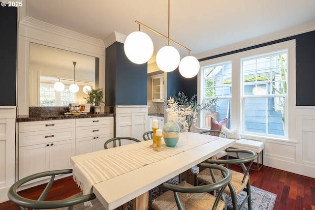 dining area with ornamental molding and dark hardwood / wood-style floors