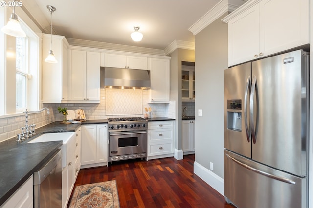 kitchen featuring sink, white cabinetry, hanging light fixtures, stainless steel appliances, and decorative backsplash