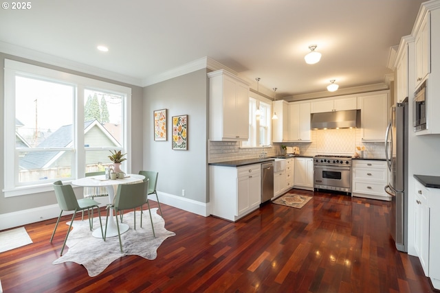 kitchen with pendant lighting, decorative backsplash, stainless steel appliances, and white cabinets