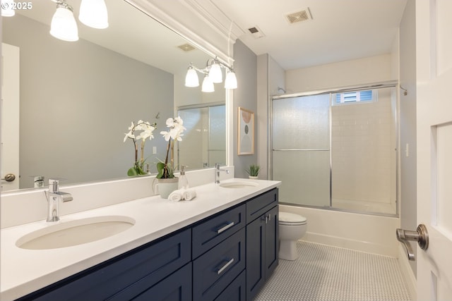 full bathroom featuring enclosed tub / shower combo, vanity, tile patterned floors, and toilet